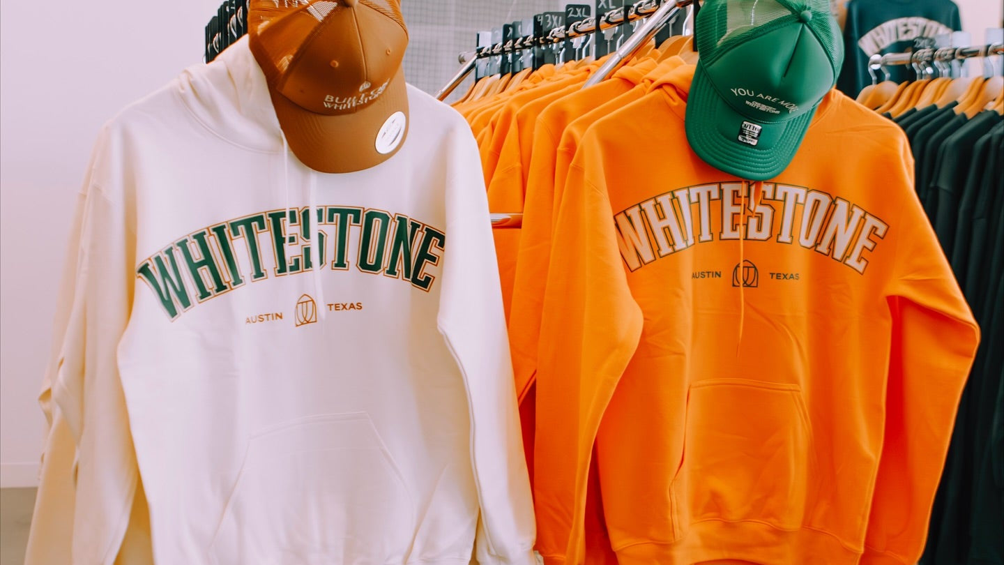 Two hoodies with 'Whitestone' branding on display in a store.
